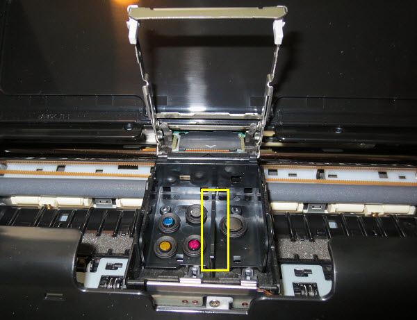 Grip the print head by the divider in the middle and lift it out of the printer