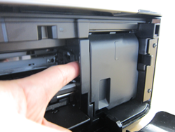 Image shows cartridge holder being pushed to the right from the left side of cartridge holder.