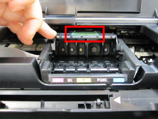 Image: Shows finger positioning on the center tab of the replacement print head